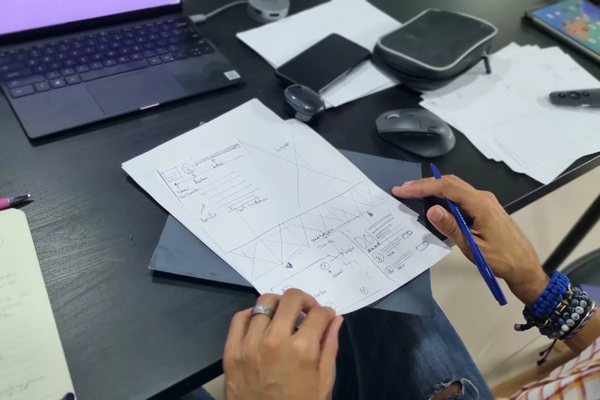 Un participante del curso revisa un boceto de interfaz hecho a lápiz